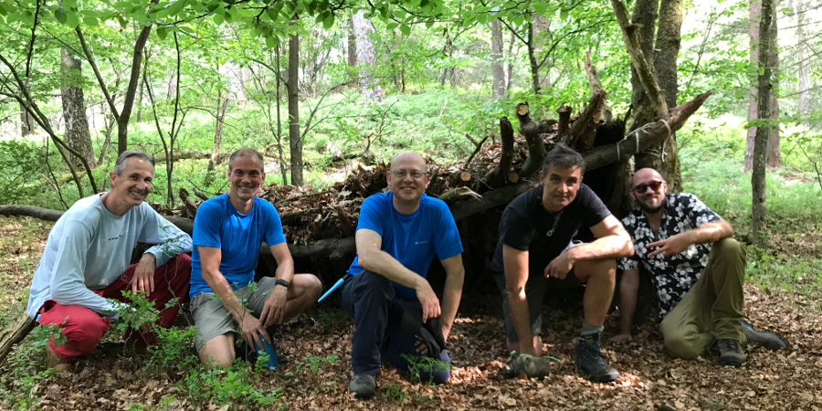 Groep mannen voor zelf gemaakte natuurlijke shelter